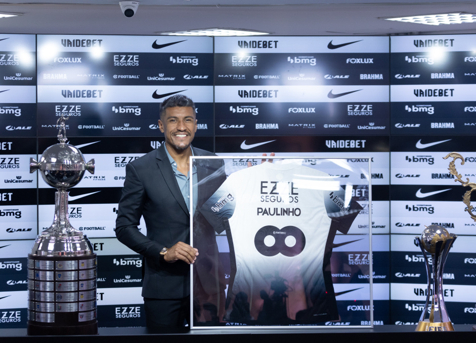 Paulinho posando junto de sua camisa eternizada, da taa da Libertadores e do Mundial